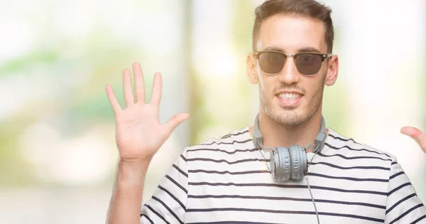 Bonito Jovem Vestindo Fones Ouvido Mostrando Apontando Para Cima Com — Fotografia de Stock