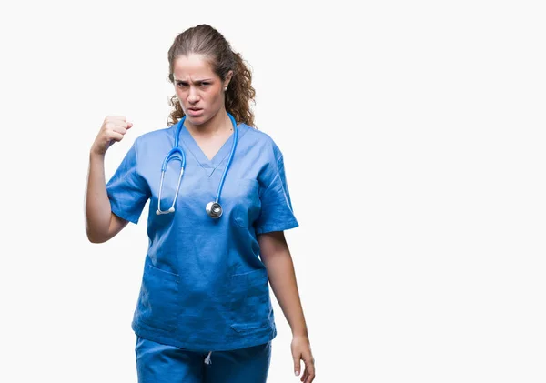 若いブルネットの医者女の子身に着けている看護師や怒りと不満と怒りで叫びながら激怒の拳を上げる狂牛病分離の背景の上に制服の外科医 怒りと攻撃的な概念 — ストック写真