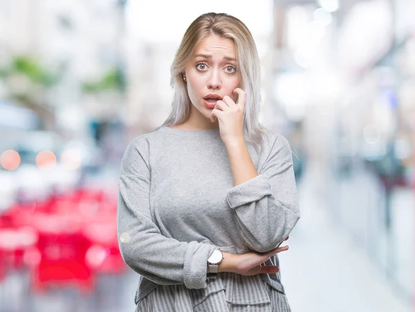年轻的金发女人在孤立的背景下 看着压力和紧张的嘴咬指甲的手 焦虑问题 — 图库照片
