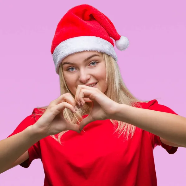 若い白人女性恋ハートマークと手で形を示す笑みを浮かべて分離の背景にクリスマス帽子をかぶっています ロマンチックな概念 — ストック写真