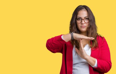 Artı boyutu genç iş kadını güzel üzerinde şık ceket ve gözlük takıyor arka plan yapıyor zaman aşımı jest eller, sinirli ve ciddi yüz ile izole