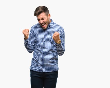 Soyutlanmış, mutlu ve heyecanlı genç bir adam kollarını kaldırmış, gülümseyen ve başarı için çığlık atan kazanan bir jest yapıyor. Kutlama konsepti.