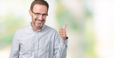 Hareketi el ile mutlu yaşasın yapıyor izole arka plan üzerinde gözlük takan yakışıklı orta yaş zarif komuta sizde. Başarı gösteren kameraya bakarak ifade onaylama.