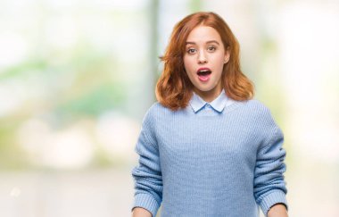 İzole arka plan kış kazak korkuyor ve şok sürpriz ifade, korku ve heyecan yüz ile giyen genç güzel kadın.