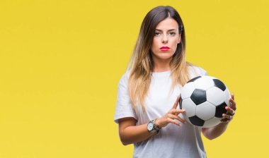 Acımak yüz ciddi düşünüyorum üstünde kendine güvenen bir ifade ile izole arka plan üzerinde futbol topu tutan genç güzel kadın