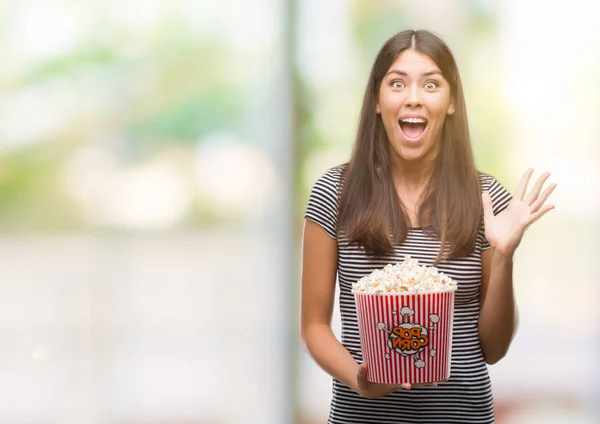 若い美しいヒスパニックが非常に幸せと興奮のポップコーンを食べて 勝者式祝う勝利と大きな悲鳴を上げる笑顔し 手を上げた — ストック写真