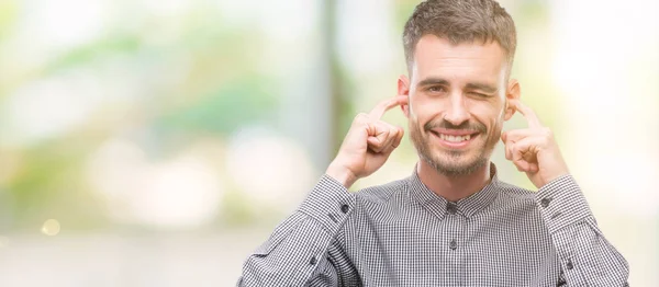 Joven Hombre Hipster Cubriendo Oídos Con Dedos Con Expresión Molesta —  Fotos de Stock