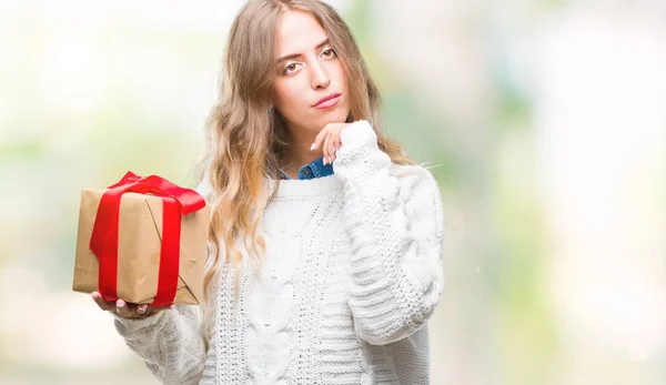 Beautiful Young Blonde Woman Holding Gift Isolated Background Serious Face — Stock Photo, Image