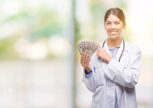 Jovem Hispânico Médico Mulher Segurando Dólares Muito Feliz Apontando Com — Fotografia de Stock