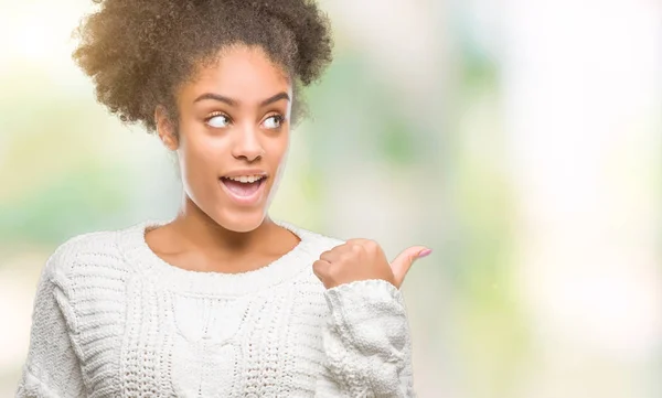 年轻的美国黑人妇女穿着冬季毛衣在孤立的背景微笑着快乐的脸看着 并指向侧面与拇指向上 — 图库照片