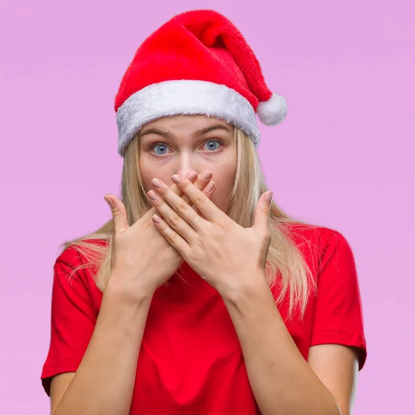 年轻的白种女人戴着圣诞帽子在孤立的背景下震惊地用手捂住嘴巴 秘密概念 — 图库照片