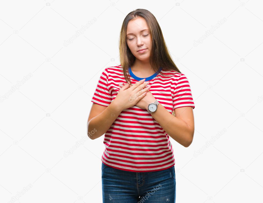 Young caucasian beautiful woman over isolated background smiling with hands on chest with closed eyes and grateful gesture on face. Health concept.