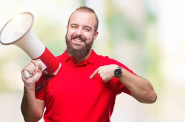 Beyaz delikanlı kendisine sürpriz yüz işaret parmağı ile izole arka plan üzerinde megafon ile bağırarak