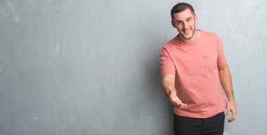 Beyaz delikanlı olarak tebrik ve konuksever dost sunan karşılıklı gülümseyen gri grunge duvarın üzerinden. Başarılı iş.