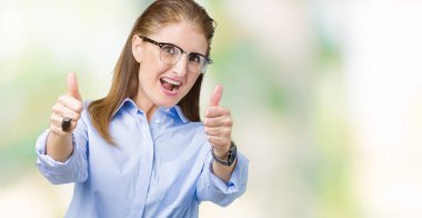 El ile pozitif jest yapıyor onaylama izole arka plan üzerinde gözlük güzel orta yaş olgun iş kadını başparmak gülümseyen ve başarı için mutlu. Kamera, kazanan jest arıyorsunuz.