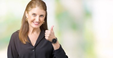 Güzel orta yaş olgun iş kadın hareketi el ile mutlu yaşasın yapıyor izole arka plan yüzünden. Kameraya bakarak başarı gösteren ile ifade onaylama.