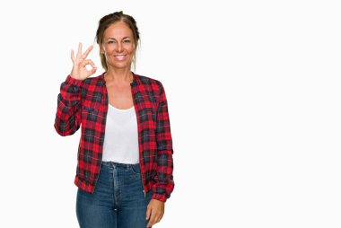 İzole arka plan el ve parmaklar ok işaretiyle yapıyor olumlu gülümseyen üzerinde rahat ceket giyen orta yaş yetişkin kadın. Başarılı ifade.