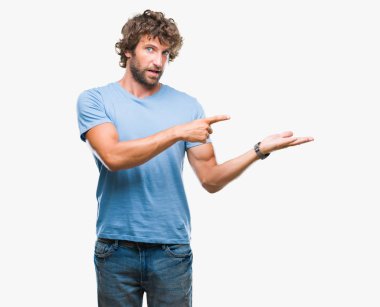 Yakışıklı İspanyol modeli adam üzerinden hayran ve el ile sunulması ve parmak ile işaret ederken kameraya gülümseyen izole arka plan.