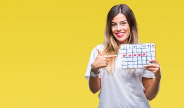 Adet takvim izole arka plan üzerinde çok mutlu el ve parmak ile işaret tutan genç güzel kadın