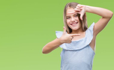 Genç güzel kız elle yapma çerçeve ve parmakları ile mutlu yüz gülümseyen izole arka plan yüzünden. Yaratıcılık ve Fotoğrafçılık kavramı.