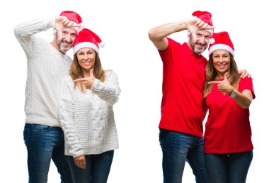 Kolaj bir orta yaş olgun güzel çift elle yapma çerçeve ve parmakları ile mutlu yüz gülümseyen beyaz izole arka plan üzerinde Noel şapka giyiyor. Yaratıcılık ve Fotoğrafçılık kavramı.