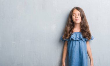 Grunge gri duvar görünümlü yan ve dik dik bakma uzağa düşünce gülümseyen genç İspanyol çocuk.