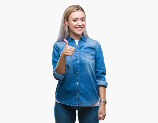 年轻的金发女人在孤立的背景下做快乐大拇指手势与手 批准表达式看相机与显示成功 — 图库照片