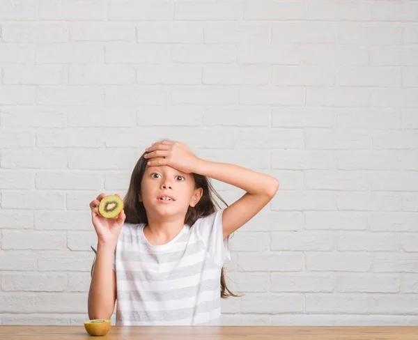 Giovane Ispanico Ragazzo Seduto Sul Tavolo Mangiare Kiwi Stressato Con — Foto Stock