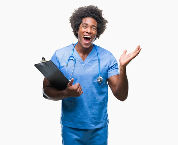 美国黑人外科医生持有剪贴板的人在孤立的背景非常高兴和兴奋 赢家表达庆祝胜利尖叫与大微笑和举手 — 图库照片