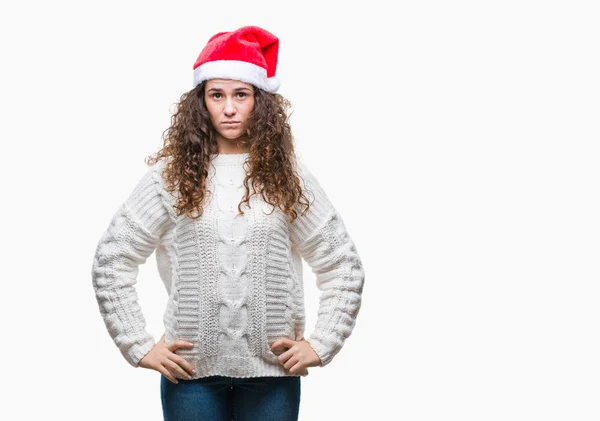 年轻的黑发女孩戴着圣诞帽在孤立的背景与严重的表情在脸上 简单而自然地看着相机 — 图库照片