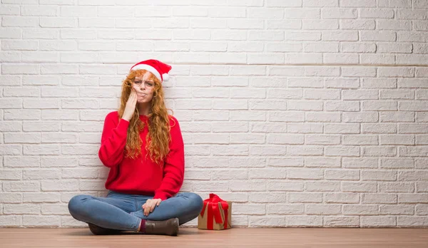 Young Redhead Woman Sitting Brick Wall Wearing Christmas Hat Touching — Stock Photo, Image