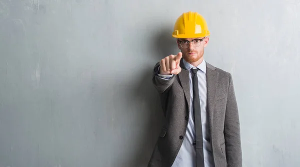若い赤毛の男性の身に着けている建築家服とカメラと指で Helment ポイント 手に署名 正面からポジティブで自信のジェスチャー — ストック写真