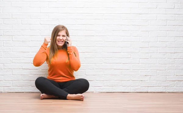 Junge Erwachsene Frau Sitzt Auf Dem Boden Über Weißen Backstein — Stockfoto