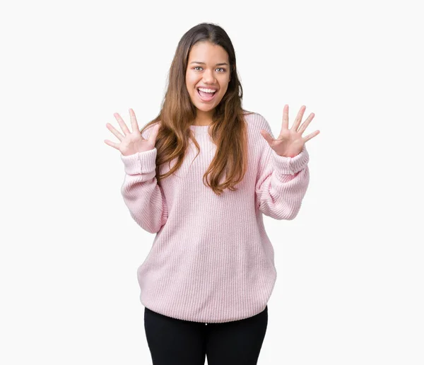 上ピンク冬セーターを着ている若い美しいブルネットの女性クレイジーを祝う背景を分離した腕を上げると成功のためびっくりし 叫んで興奮して目を開きます 勝者の概念 — ストック写真