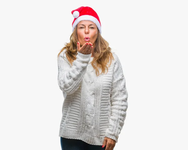 オンエアされて素敵なセクシーな手でキスを吹いてカメラ目線孤立の背景にクリスマスの帽子を着て中年年配のヒスパニック系女性 愛情表現 — ストック写真