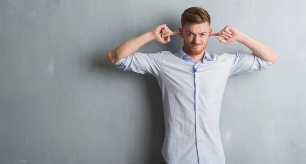 Joven Hombre Negocios Pelirrojo Sobre Pared Grunge Gris Cubriendo Las — Foto de Stock