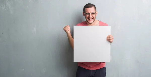 Joven Hombre Caucásico Sobre Pared Gris Grunge Sosteniendo Una Pancarta — Foto de Stock