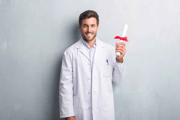 Handsome Young Doctor Man Grey Grunge Wall Holding Diploma Happy — Stock Photo, Image