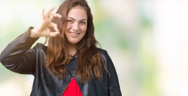 Artı boyutu genç kadın güzel üzerinde bir moda deri ceket giyiyor arka plan el ve parmaklar ok işaretiyle yapıyor olumlu gülümseyen izole. Başarılı ifade.