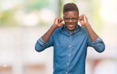 Afrikalı-Amerikalı genç kulakları ile yüksek sesle müzik gürültü rahatsız ifade parmaklarıyla kapsayan izole arka plan üzerinde. Sağır kavramı.