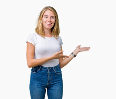 Açık el ile doğal gülümseyen girmek için davet izole arka plan üzerinde rahat beyaz t-shirt giyen güzel genç kadın
