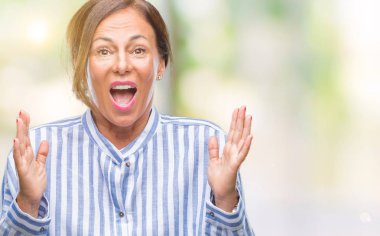 Orta yaş üst düzey İspanyol kadın yüzünden kızgın ve silah ile başarı için deli kutluyor izole arka plan ortaya çıkar ve heyecanlı çığlık gözler kapalı. Kazanan kavramı