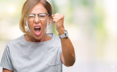 Kızgın arka plan üzerinde gözlük takan orta yaş İspanyol kadın kıdemli izole ve kızgın yetiştirme hayal kırıklığı ve öfke ile bağırarak süre öfkeli yumruk. Öfke ve agresif kavramı.