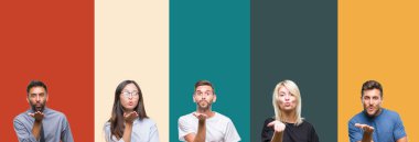 Kolaj bir öpücük el ile güzel ve seksi olmak hava üfleme kamera bakarak renkli çizgili izole arka plan üzerinde farklı etnik genç insan. Aşk ifade.