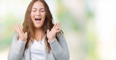 Güzel izole arka plan üzerinde kış ceket giyen boyutu genç kadın artı kızgın ve silah ile başarı için deli kutluyor kaldırdı ve heyecanlı çığlık gözler kapalı. Kazanan kavramı