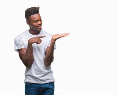 Genç Afro-Amerikan adam üzerinden hayran ve el ile sunulması ve parmak ile işaret ederken kameraya gülümseyen izole arka plan.