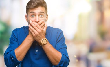 Yakışıklı delikanlı izole arka plan ağız hata için elleriyle kapsayan şok içinde. Gizli kavramı.