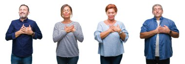 Göğüs kapalı gözler ve yüzünde minnettar jest ile kolaj bir grup zarif orta yaş ve üst düzey kişi ile gülümseyen izole arka plan üzerinde eller. Sağlık kavramı.