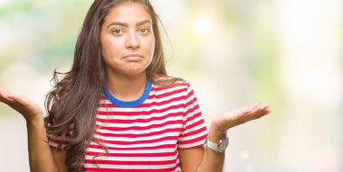 Genç güzel Arap kadın izole arka plan clueless ve şaşkın bir ifadeyle kollar ve eller kaldırdı. Şüphe kavramı.