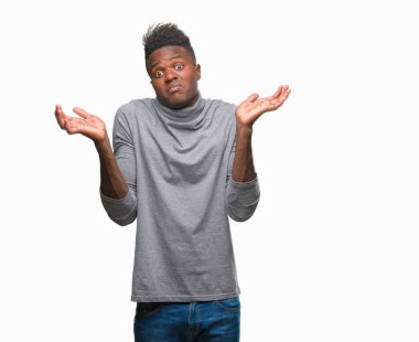 Afrikalı-Amerikalı genç izole arka plan clueless ve şaşkın bir ifadeyle kollar ve eller ortaya çıkar üzerinden. Şüphe kavramı.
